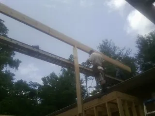 Carpenter setting a ridge beam over a new addition frame — Ice Dam Removal by Roofing Brothers in Idanha