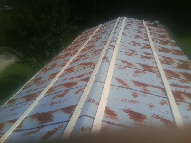 Rusted metal roof panels with new wood purlins before replacement — Storm Damage Roof Repair in Idanha by Roofing Brothers